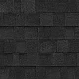 A close-up, top-down view of black architectural roof shingles with a layered, rectangular texture.