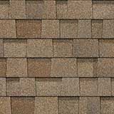 A close-up view of tan and brown architectural asphalt roofing shingles arranged in an overlapping pattern.