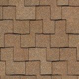 A repeating pattern of rectangular, sandy-brown architectural roof shingles with a staggered, interlocking design.