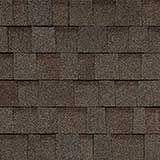 A textured, brown asphalt shingle roof pattern with overlapping rectangular tiles.