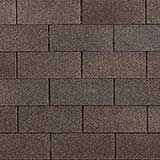 A close-up of dark brown, rectangular roof shingles arranged in an overlapping, horizontal brick-like pattern.