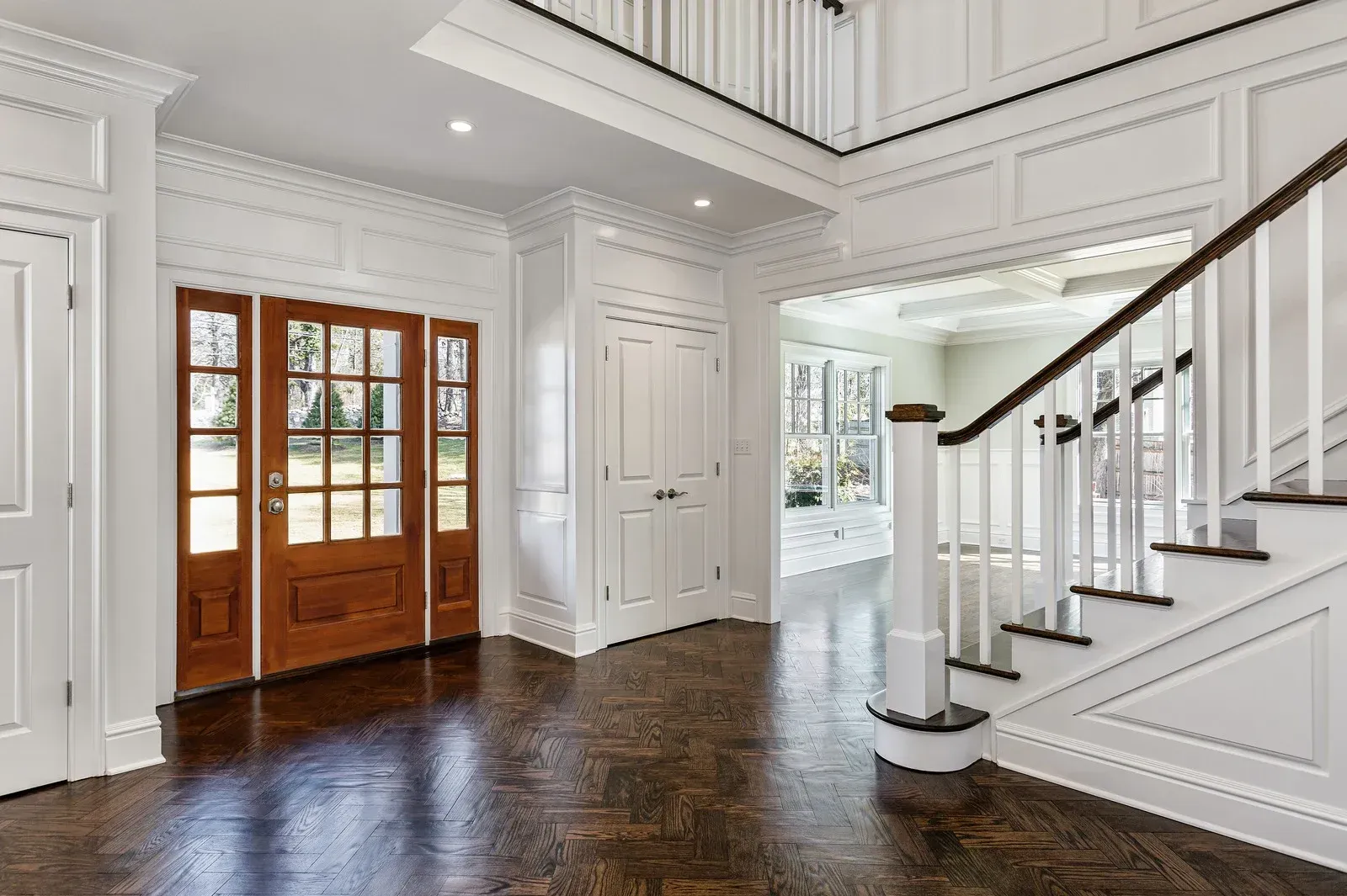 Low-angle shot of a house exterior showing a white gutter and soffit against gray siding under a clear blue sky.