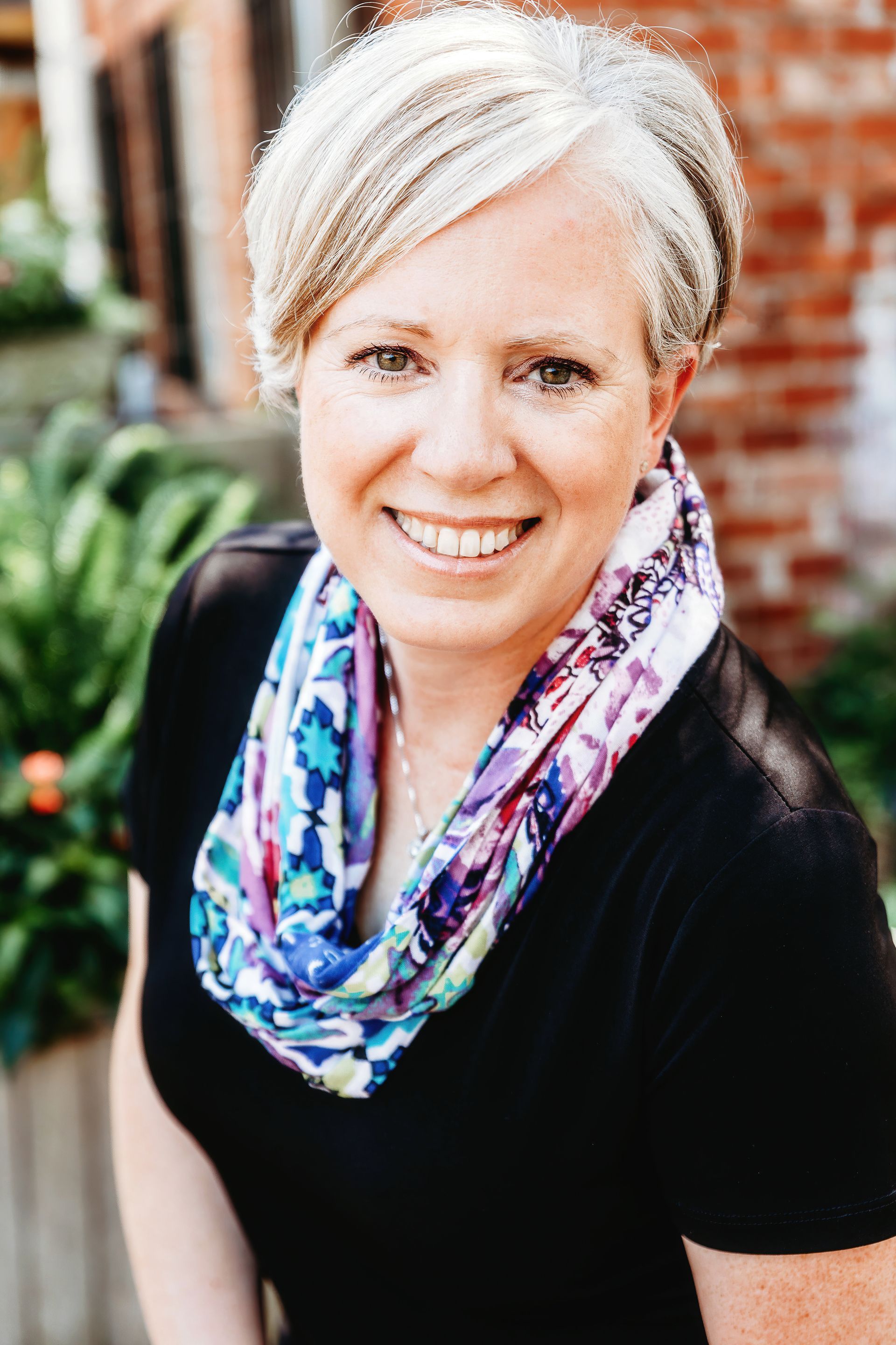 Agency owner Nancy Miller smiling and wearing a floral scarf