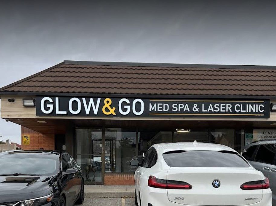 A white car is parked in front of a building that says glow & go med spa & laser clinic.