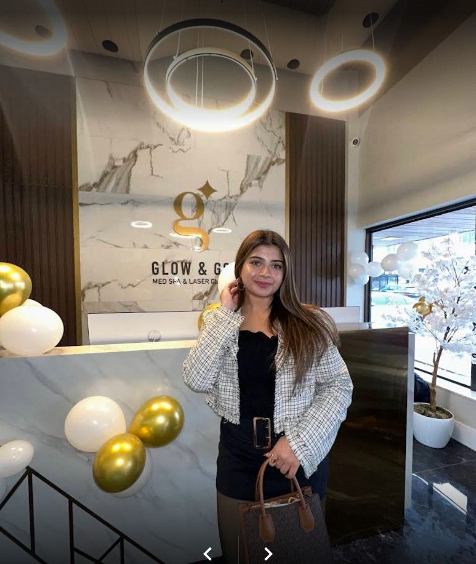 A woman is standing in front of a counter in a room with balloons.