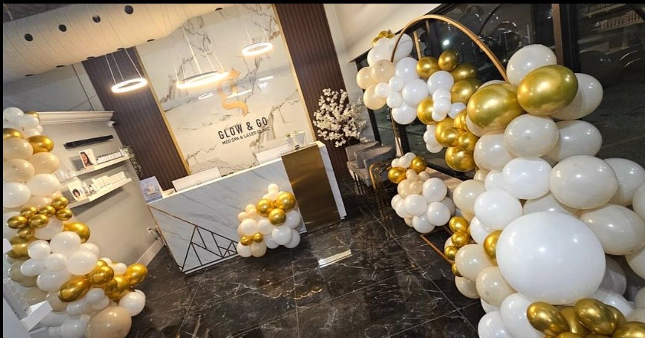 A room decorated with white and gold balloons and a reception desk.