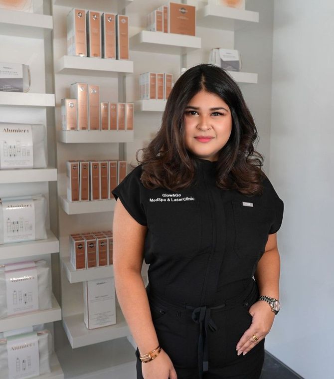 A woman stands in front of a wall of shelves filled with beauty products