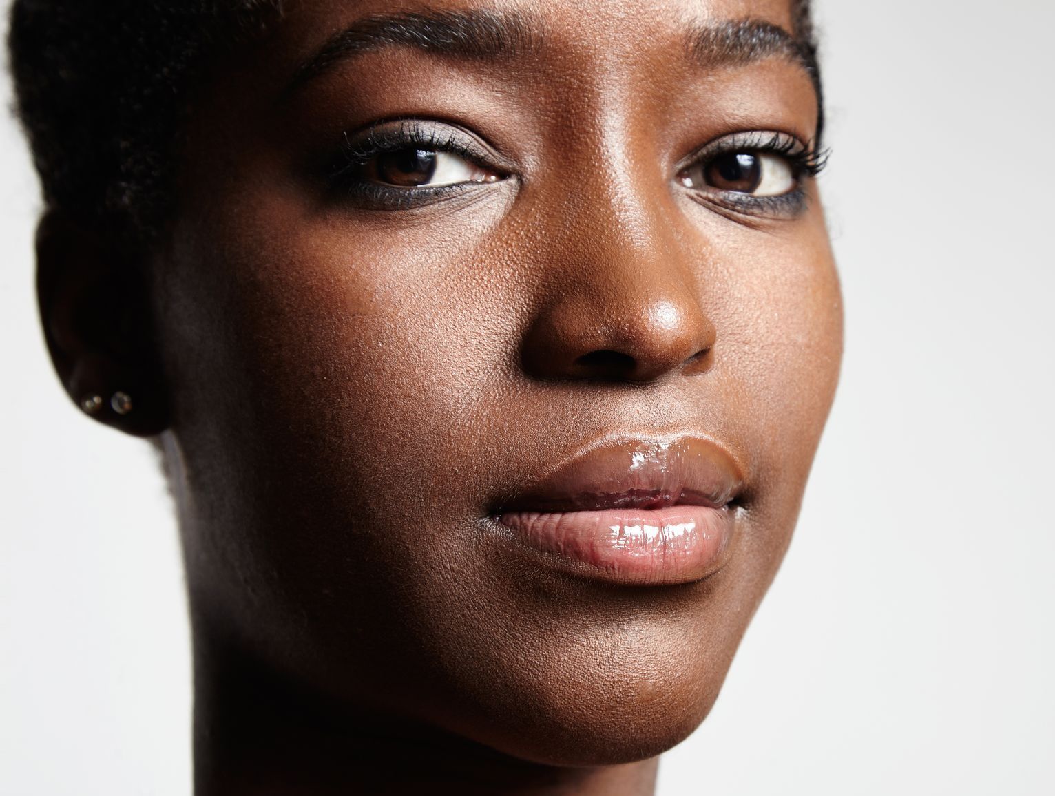 A close up of a woman 's face and neck on a white background.