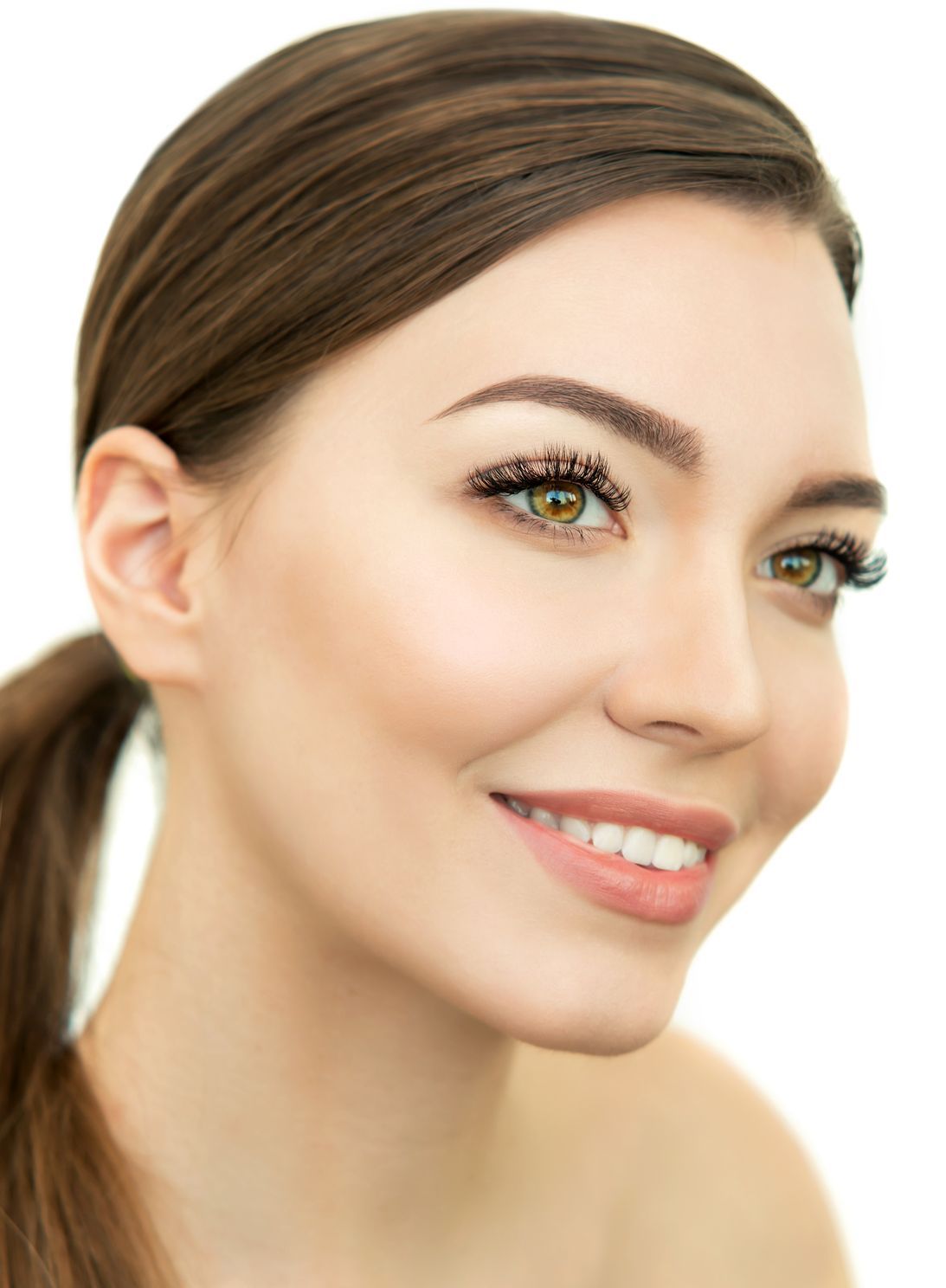 A close up of a woman 's face with a ponytail and smiling.