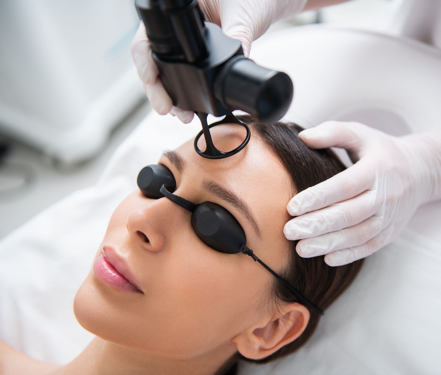 A woman is getting a laser treatment on her face.