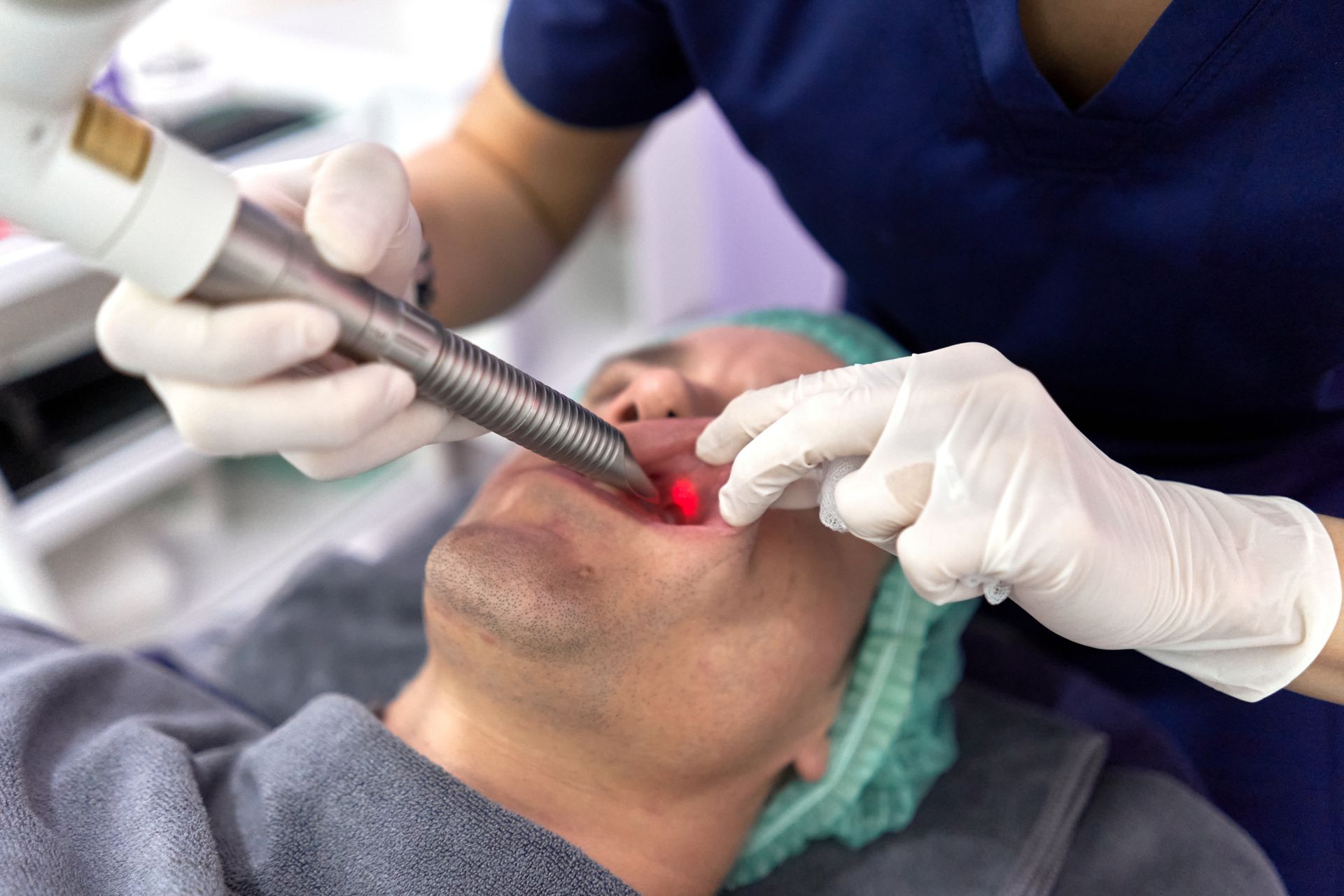 A man is getting a laser treatment on his face.