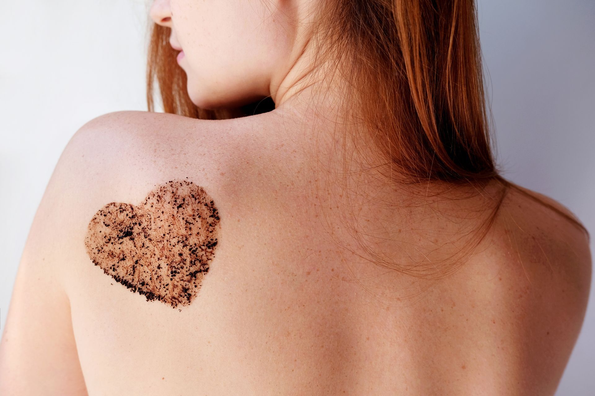 A woman has a heart shaped scrub on her back.