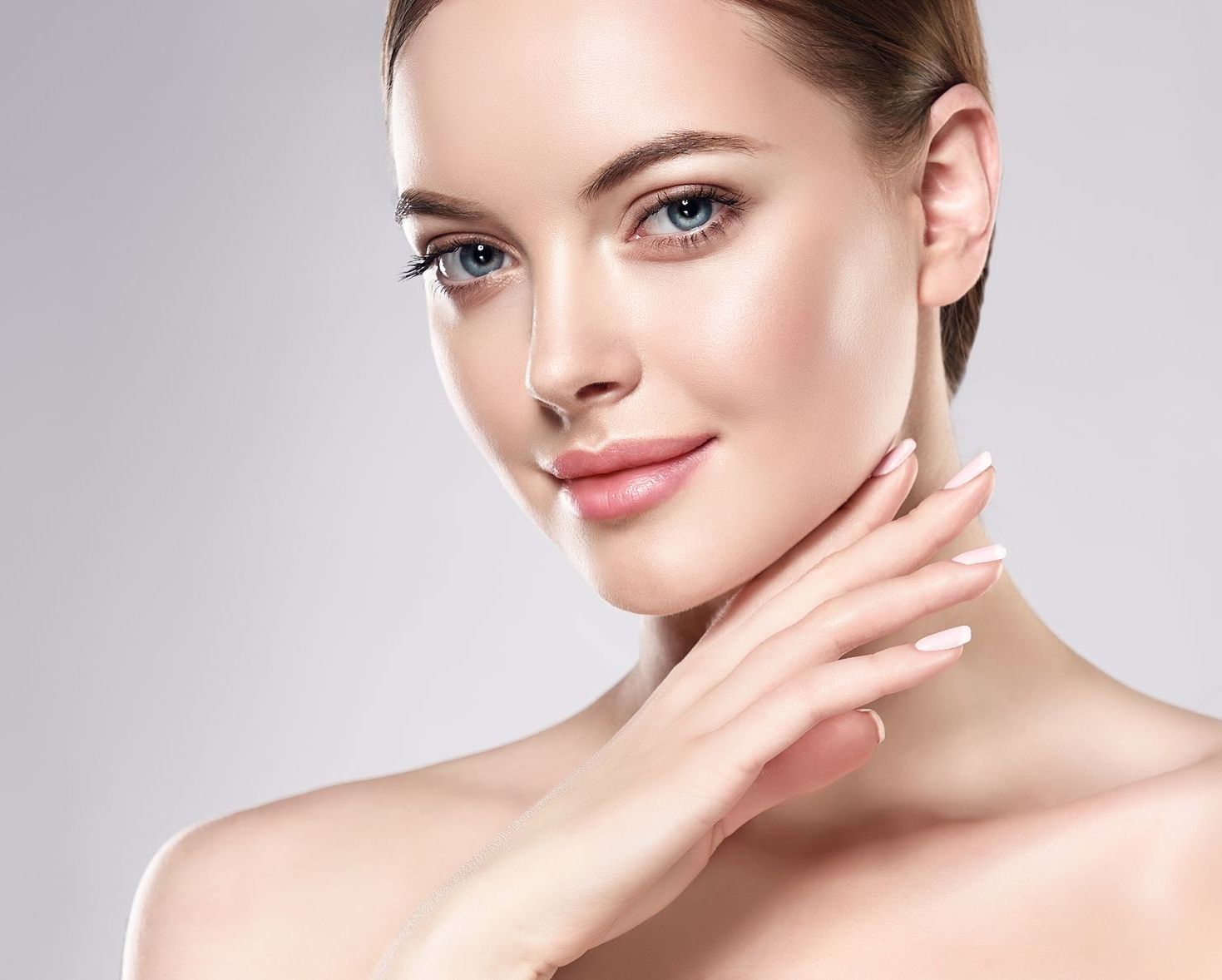 A close up of a woman 's face with her hand on her chin.