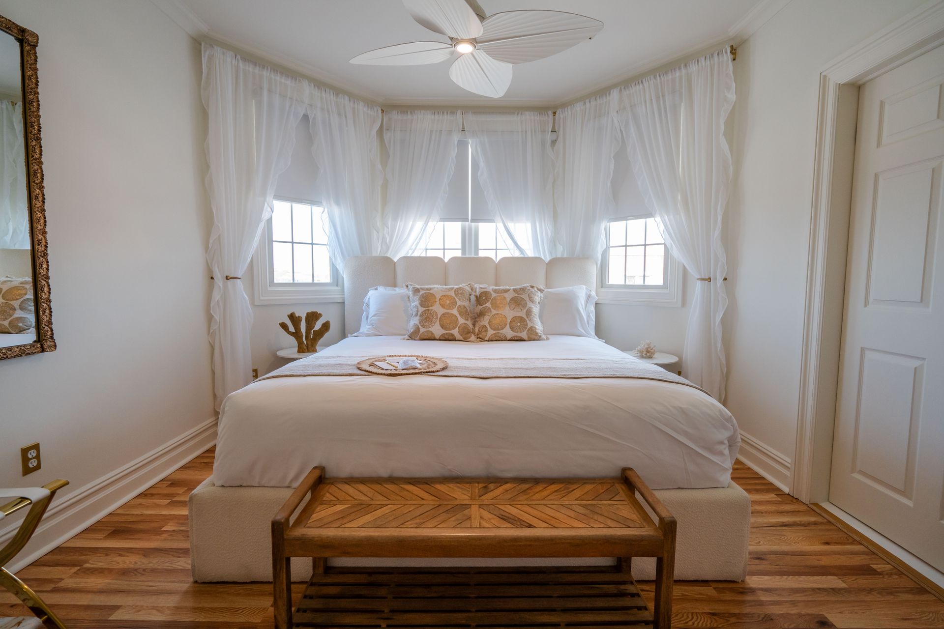 A bed with white sheets and a book on it.
