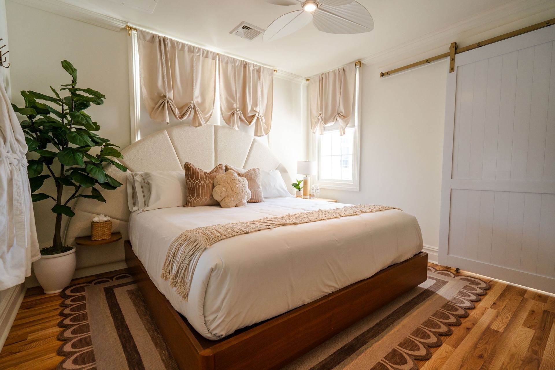 A bed with white sheets and a book on it.