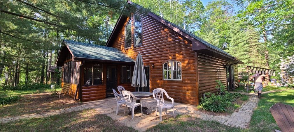 A Log Cabin With a Table and Chairs – MN - Lifetime Staining and Log Restoration
