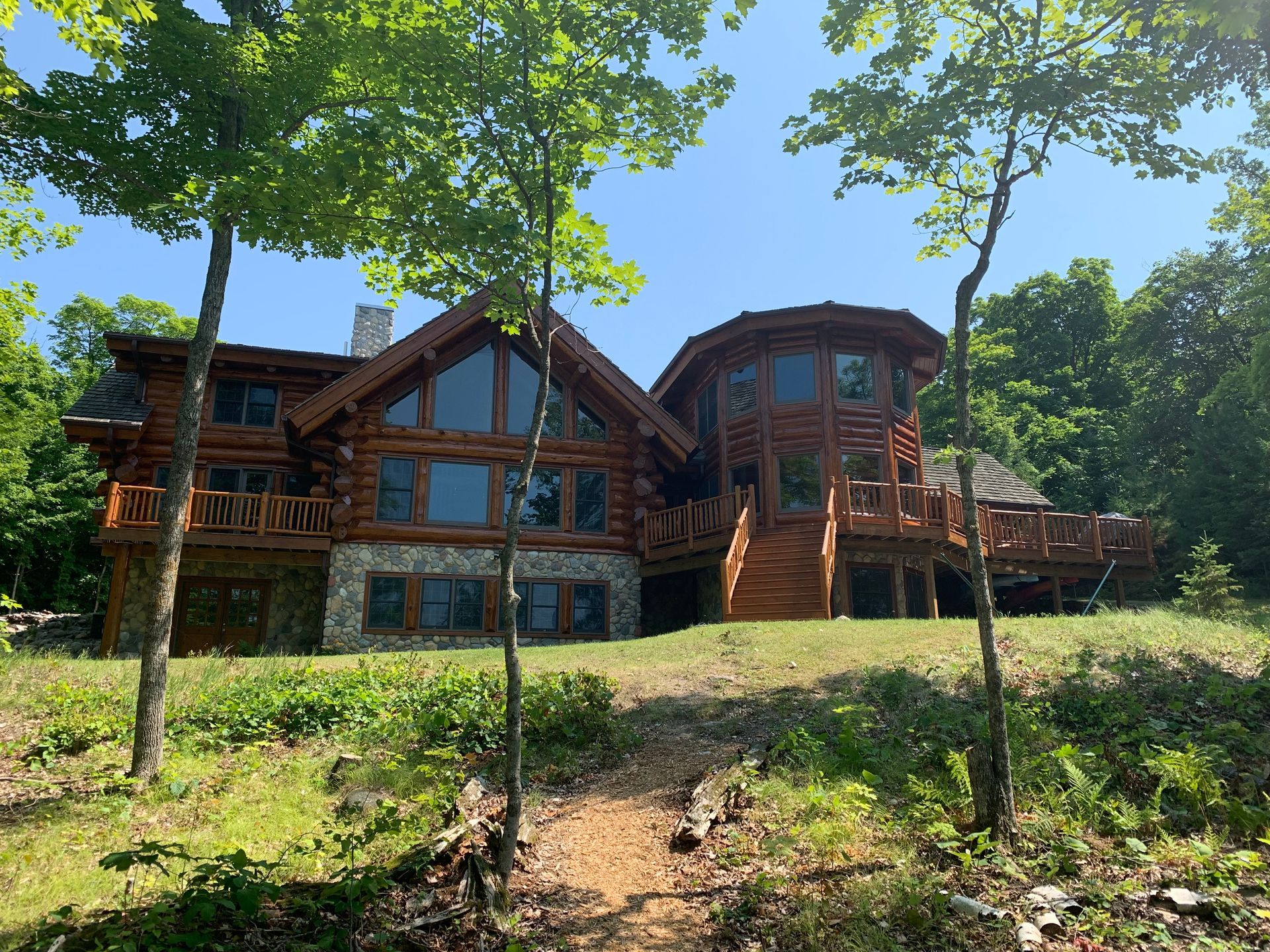 Log Cabin Surrounded by Trees – MN - Lifetime Staining and Log Restoration