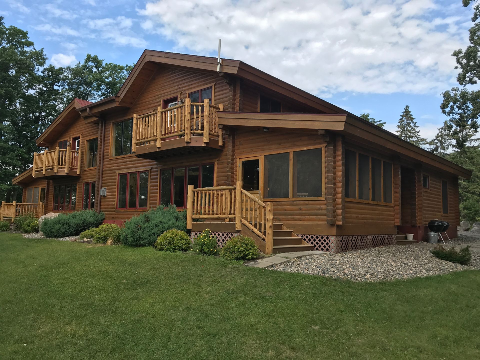 A Large Wooden House With Windows – MN - Lifetime Staining and Log Restoration