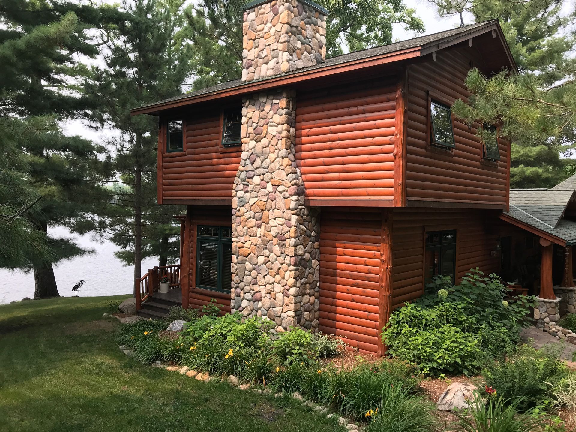 A Log Cabin With a Stone Chimney – MN - Lifetime Staining and Log Restoration