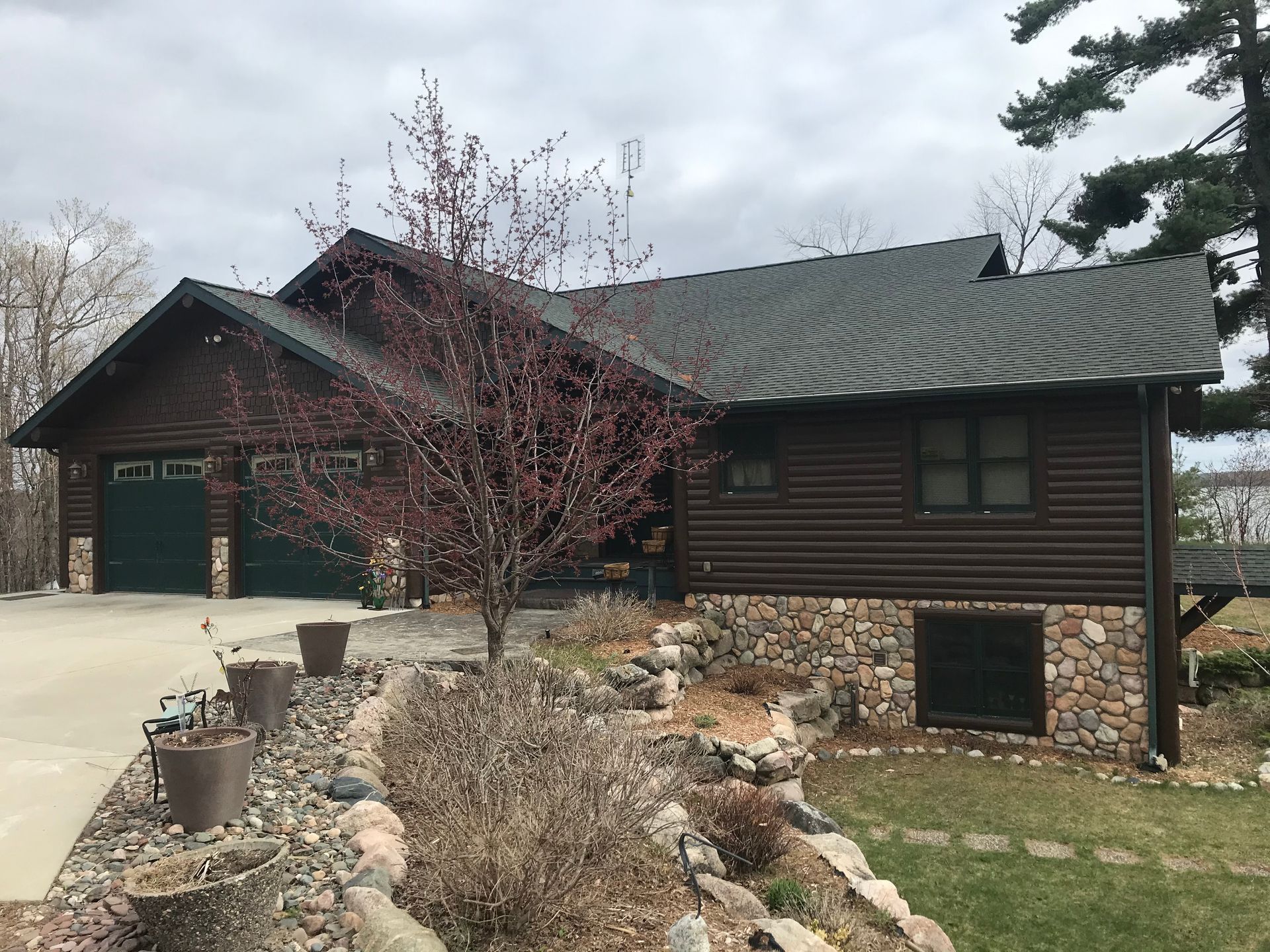 A Large House With a Green Garage Door – MN - Lifetime Staining and Log Restoration