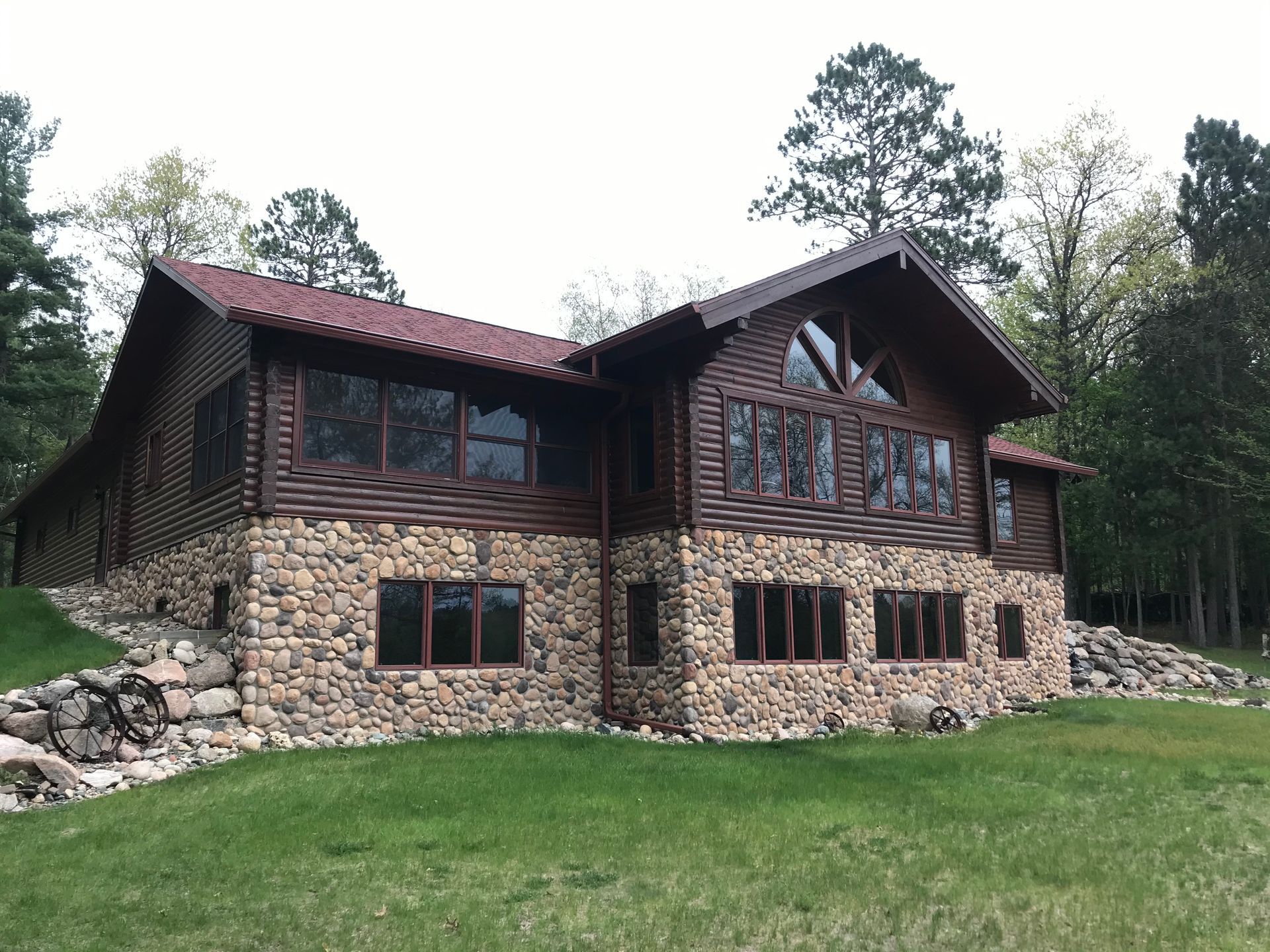 Cabin Sitting on Top of a Lush Green Hillside – MN - Lifetime Staining and Log Restoration