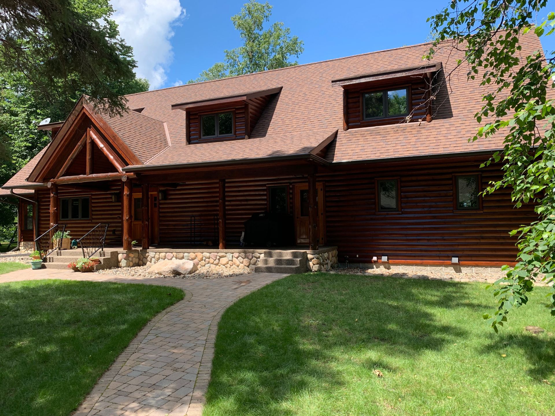 A Large Log Cabin With a Brick Walkway – MN - Lifetime Staining and Log Restoration