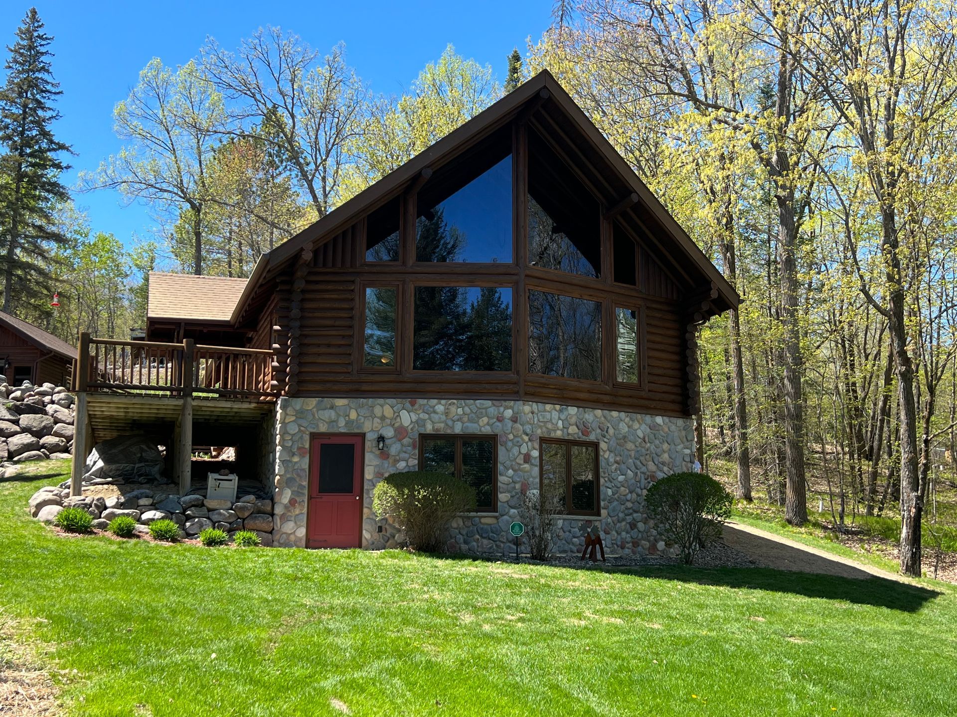 A Large Log Cabin Surrounded by Trees – MN - Lifetime Staining and Log Restoration
