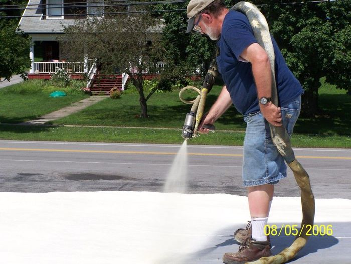 A man is spraying a concrete surface with a hose