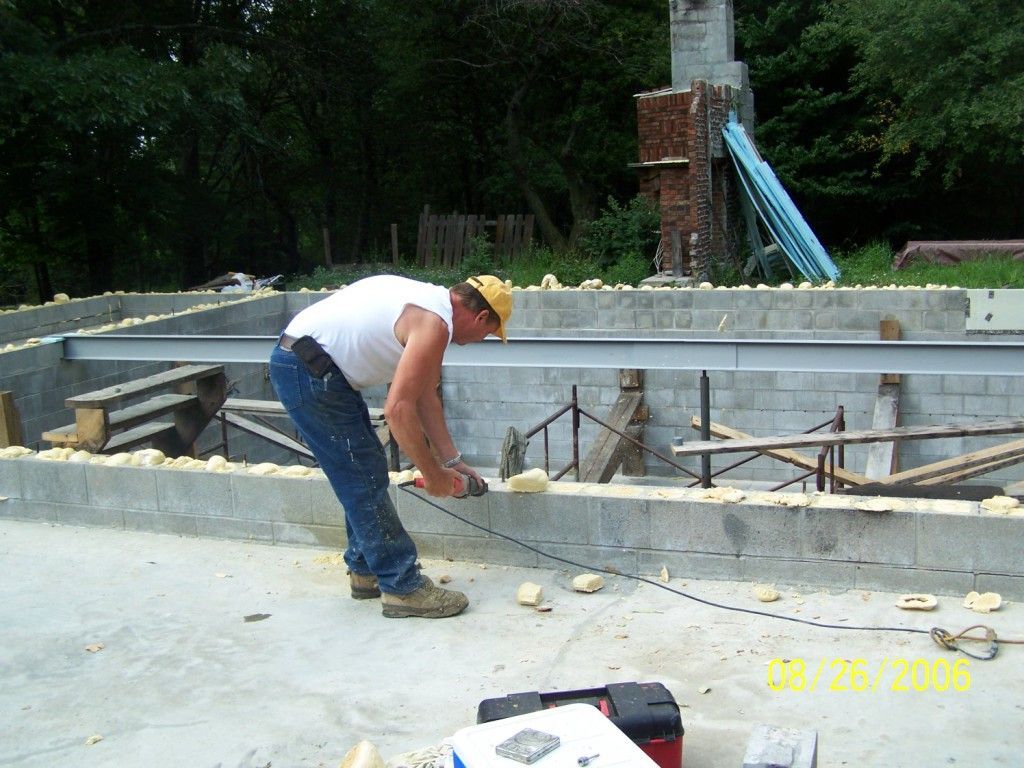 A man wearing a hard hat is working on a construction site