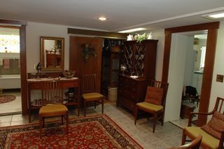 Living room with dark wood furniture, rug, and access to other rooms.