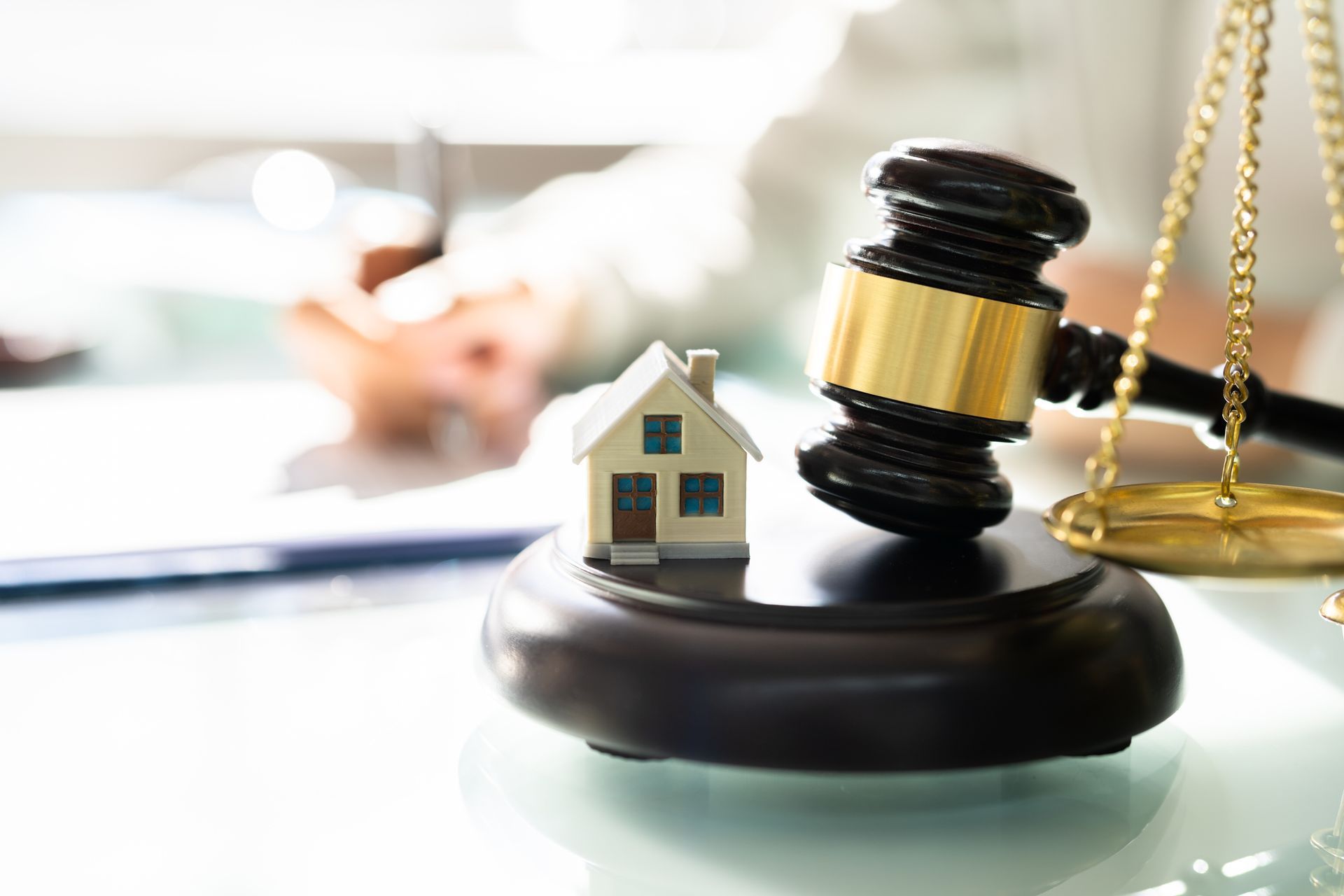 Conveyancing solicitor handling property transfer with house model, gavel, and legal documents.
