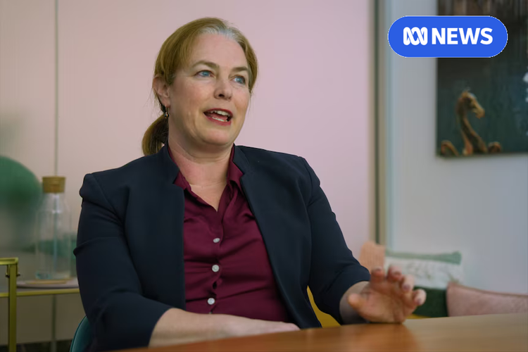 Woman in a dark blazer and burgundy shirt speaks at a table, ABC News logo in the corner.