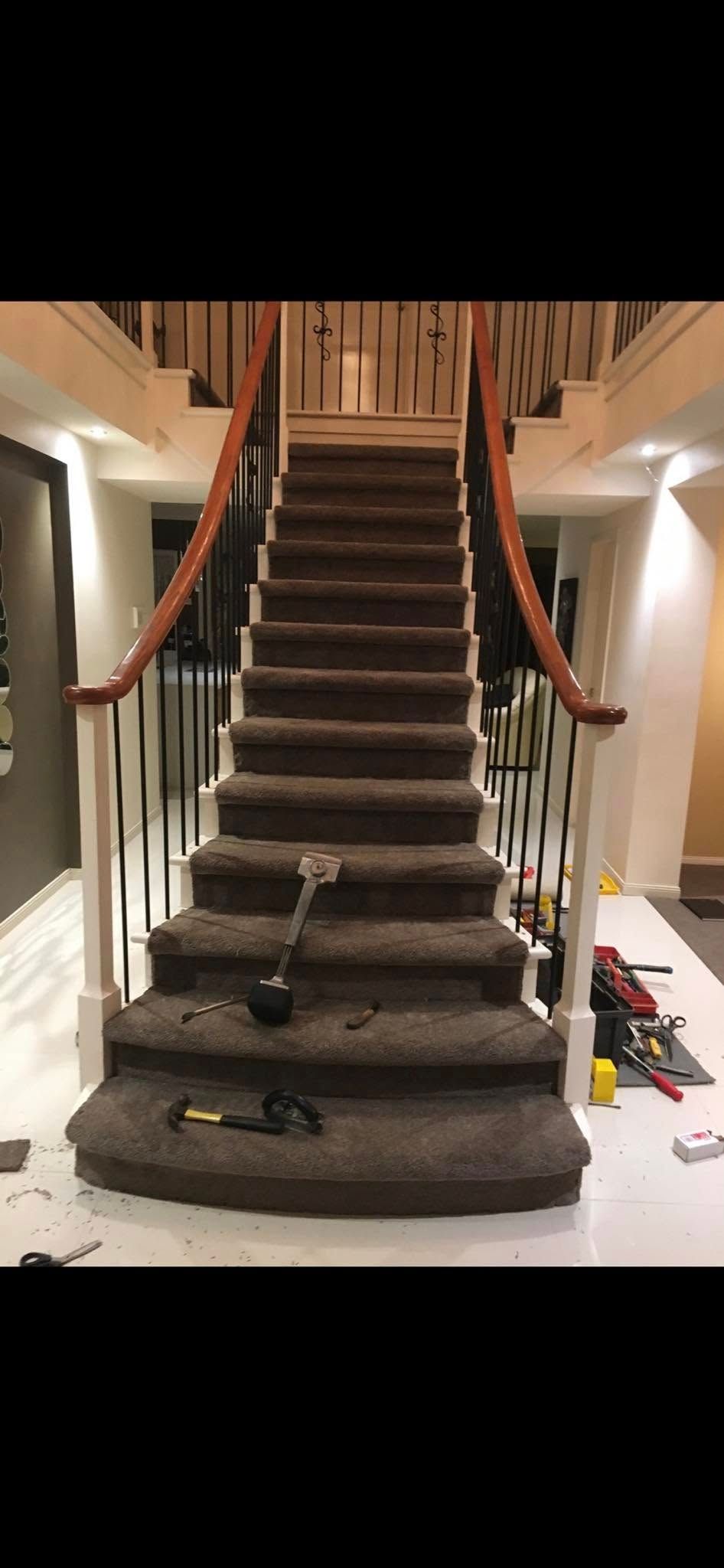 A staircase with a carpeted staircase and a wooden railing.