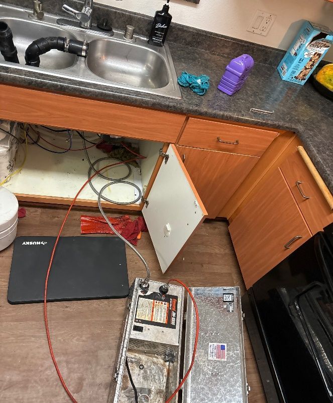 A kitchen with a sink , cabinets , and a stove.