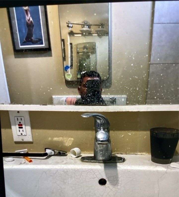 A man is taking a picture of himself in a bathroom mirror