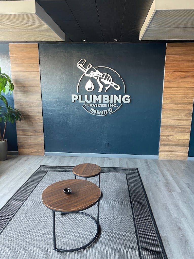 A room with two tables and a plumbing sign on the wall.