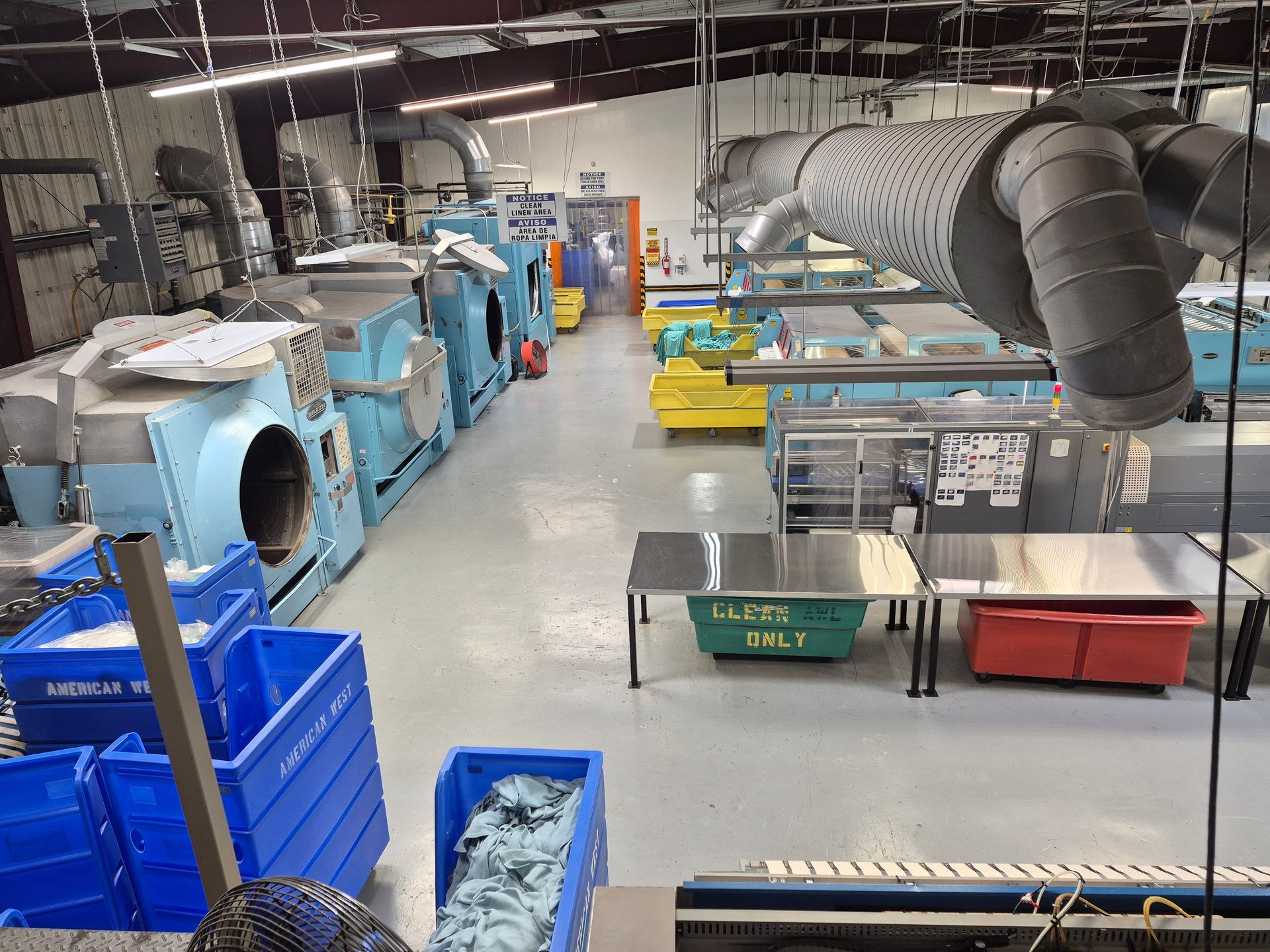Blue industrial linen folding machine in a factory.