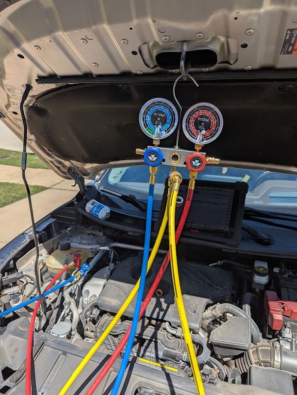The hood of a car is open and a bunch of hoses are connected to it. | Compassion Auto Care LLC