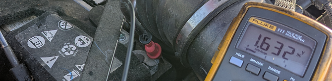 A close up of a fluke thermometer on a car engine. | Compassion Auto Care LLC