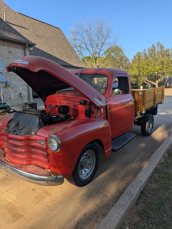 An old red truck with the hood up is parked on the side of the road. | Compassion Auto Care LLC