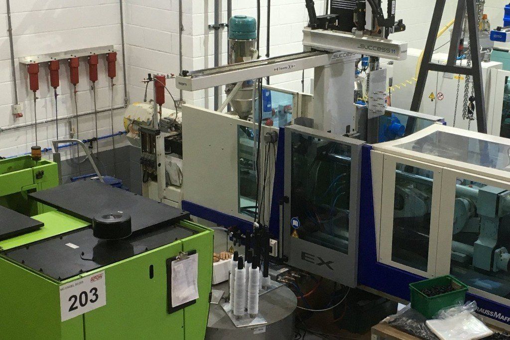 A factory with a lot of machines and a green machine with the number 203 on it.