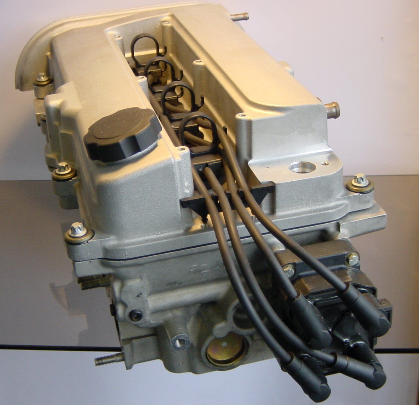 A close up of a car engine with wires coming out of it