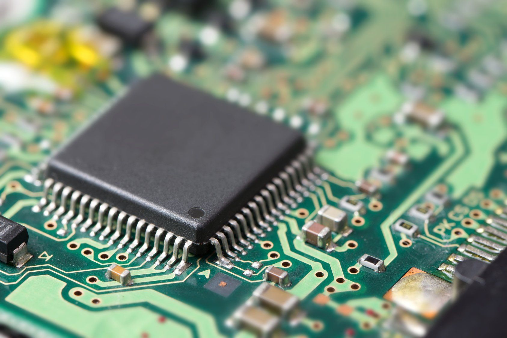 A close up of a computer chip on a green motherboard