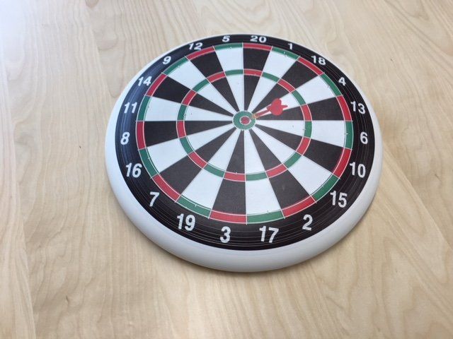 A dart board on a wooden table with the number 17 in the center