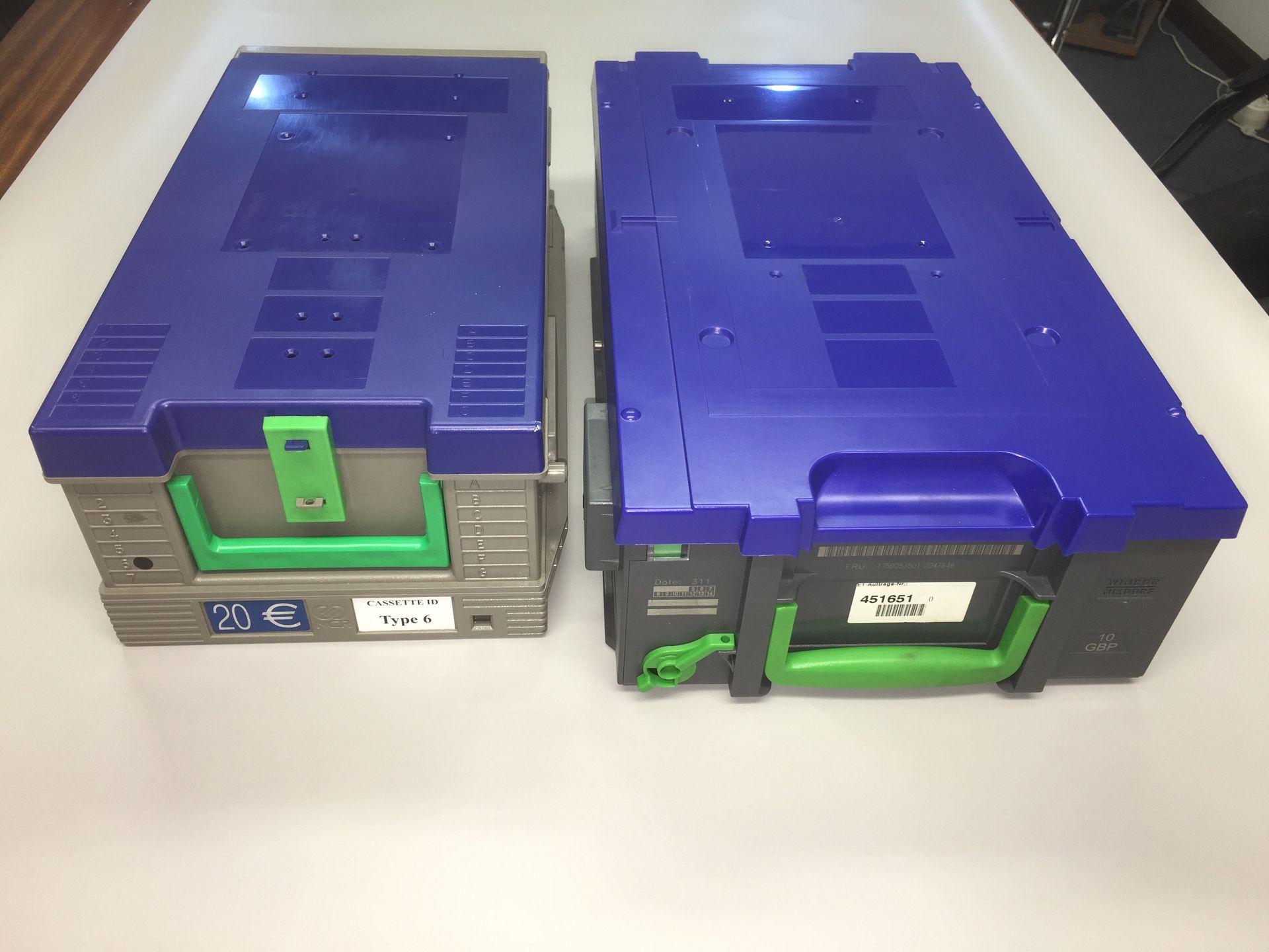 Two blue boxes with green handles on a white surface
