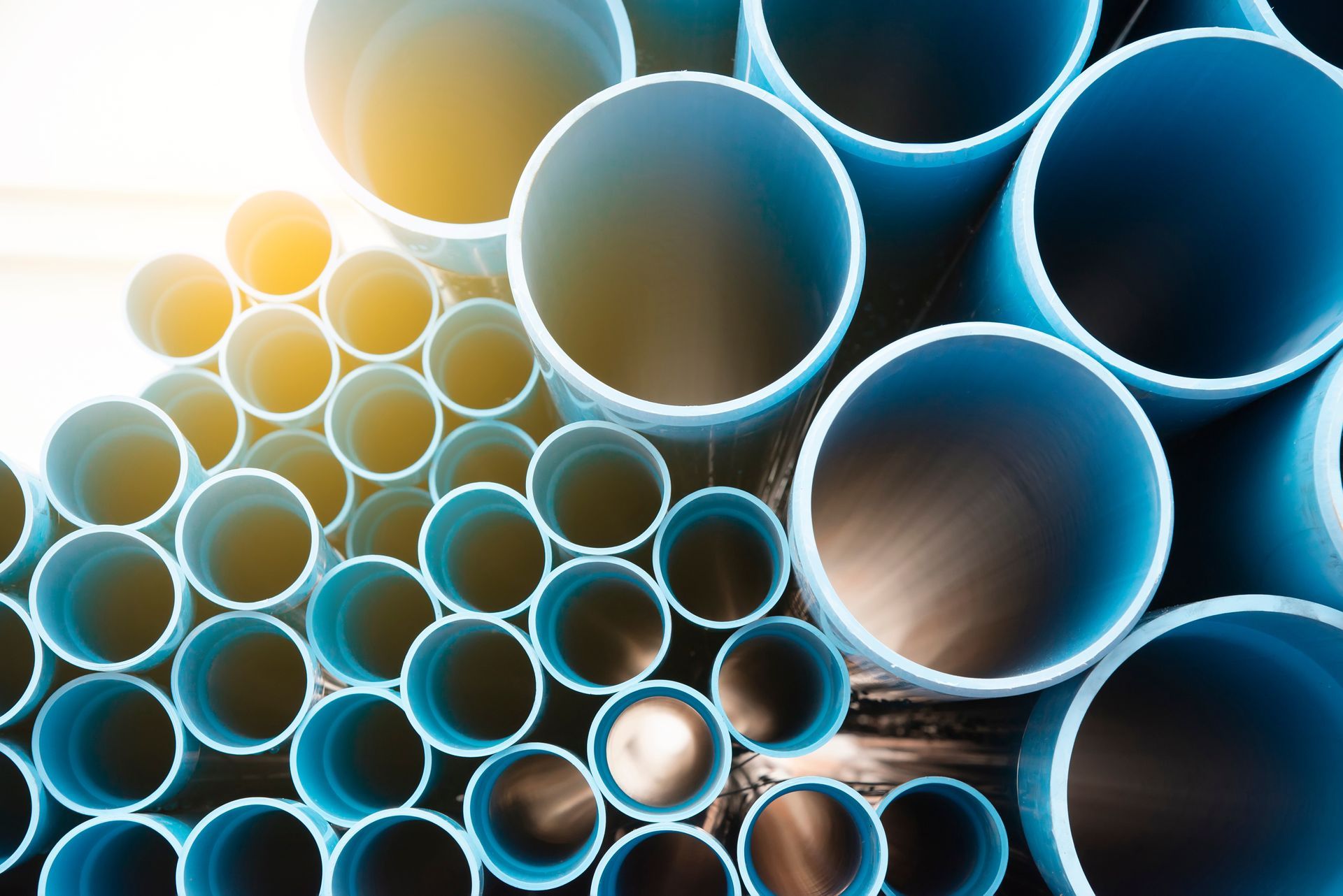 A pile of blue and black plastic pipes stacked on top of each other.