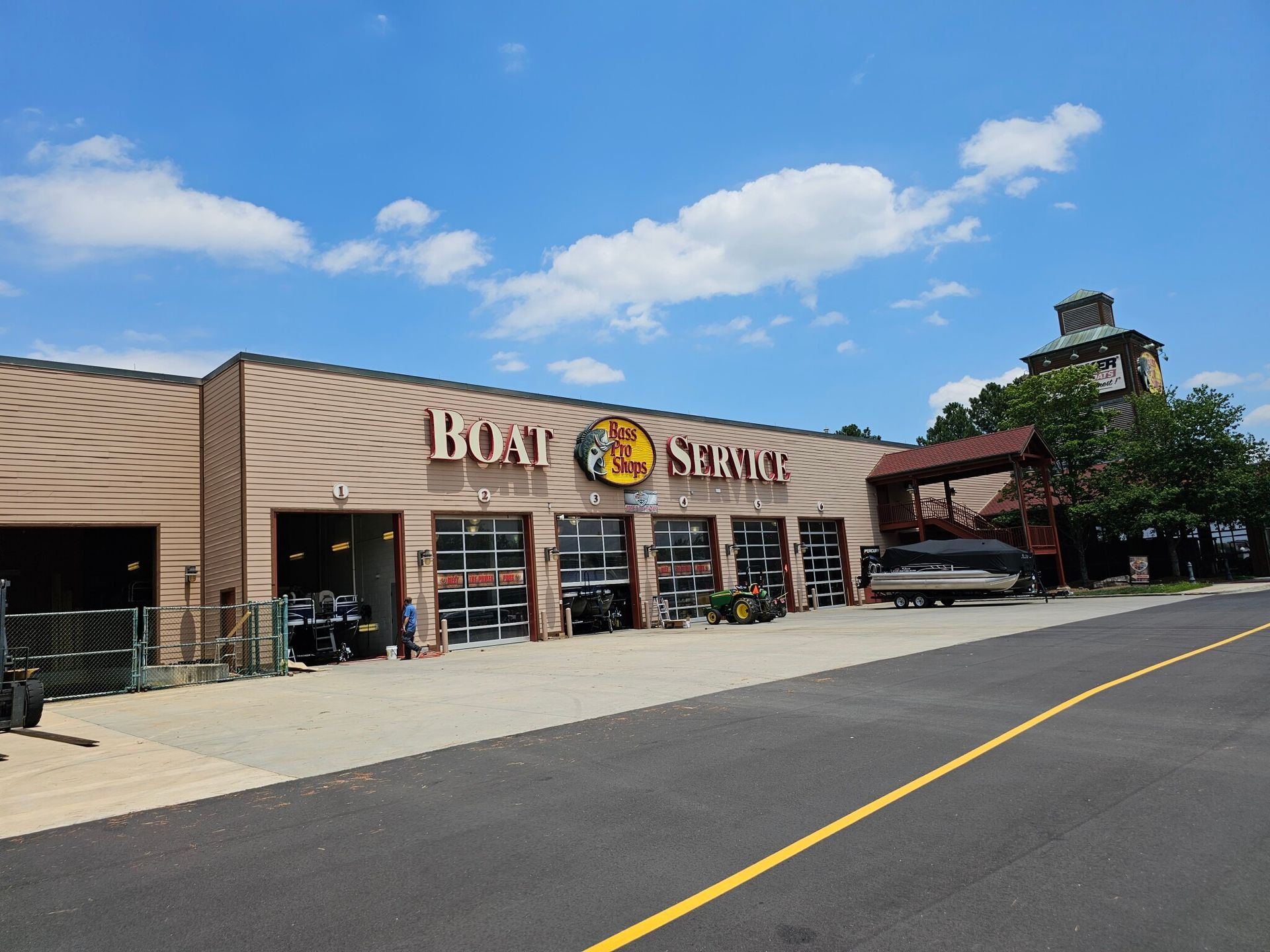 Bass Pro Shops Boat Service building with service bays under a blue sky.
