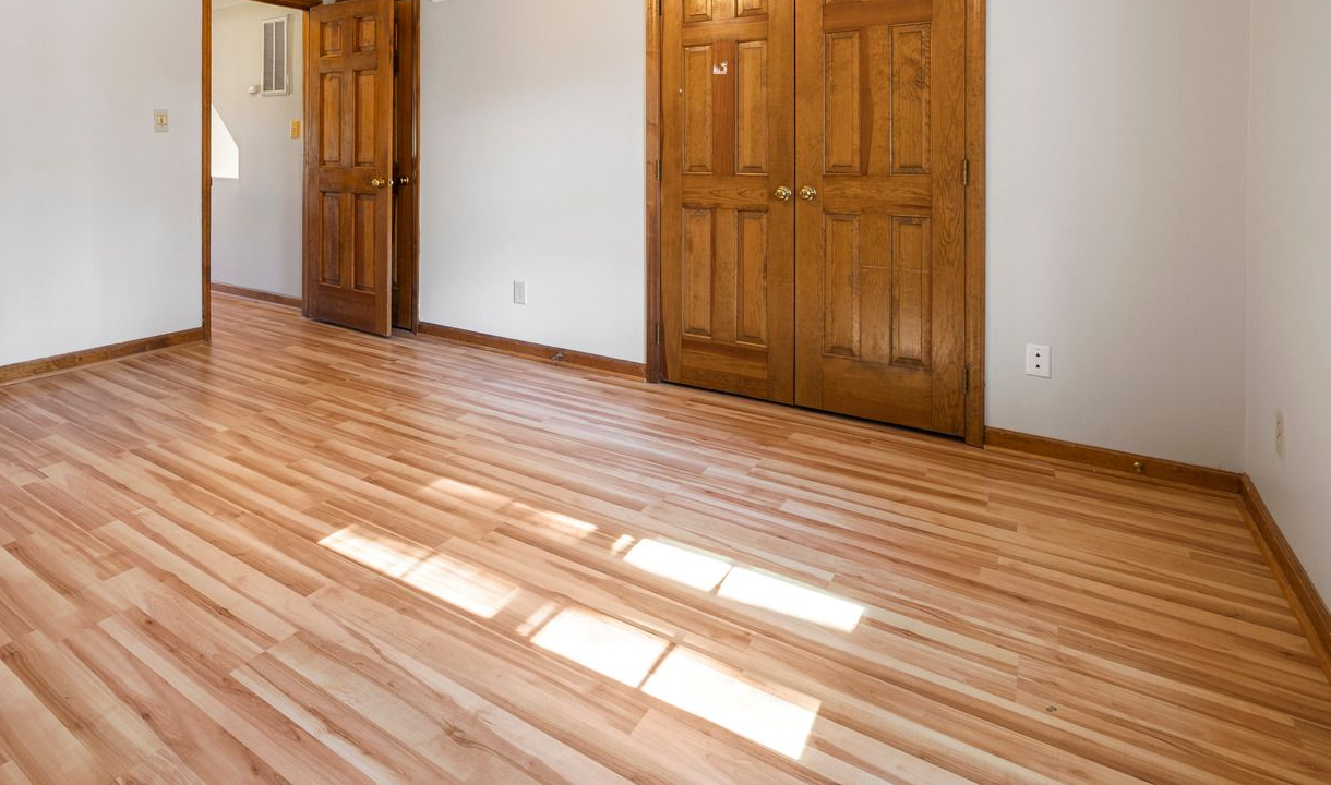 Hallway with speckled floor, tan walls, exit sign, and paint buckets.
