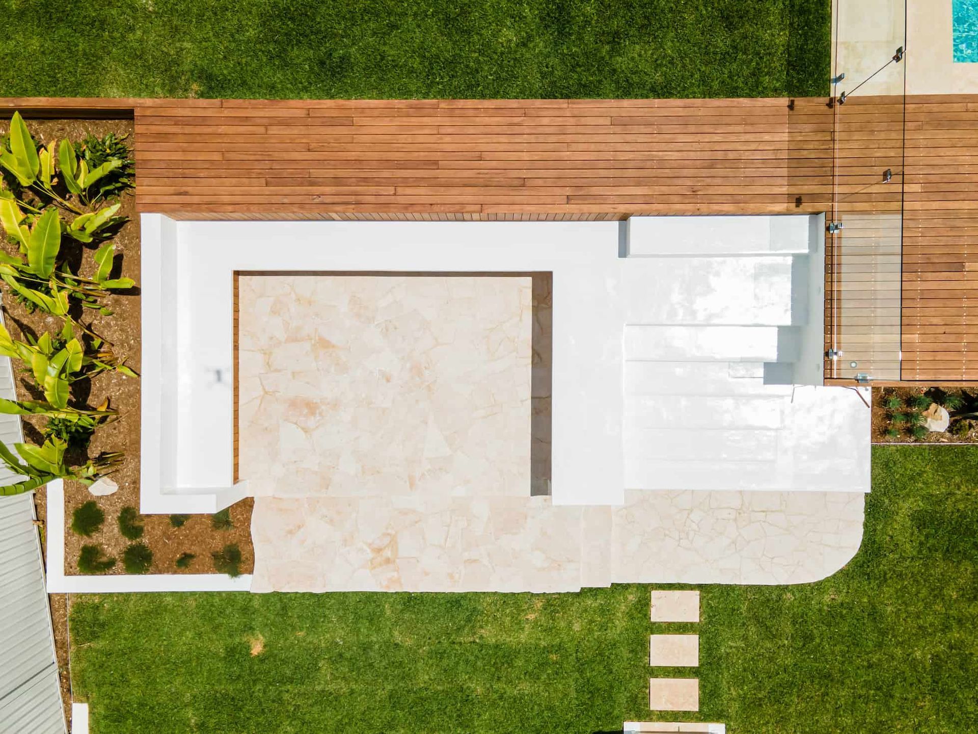 Stone flooring and concrete seating surrounded by decking - Hardscaping Gold Coast