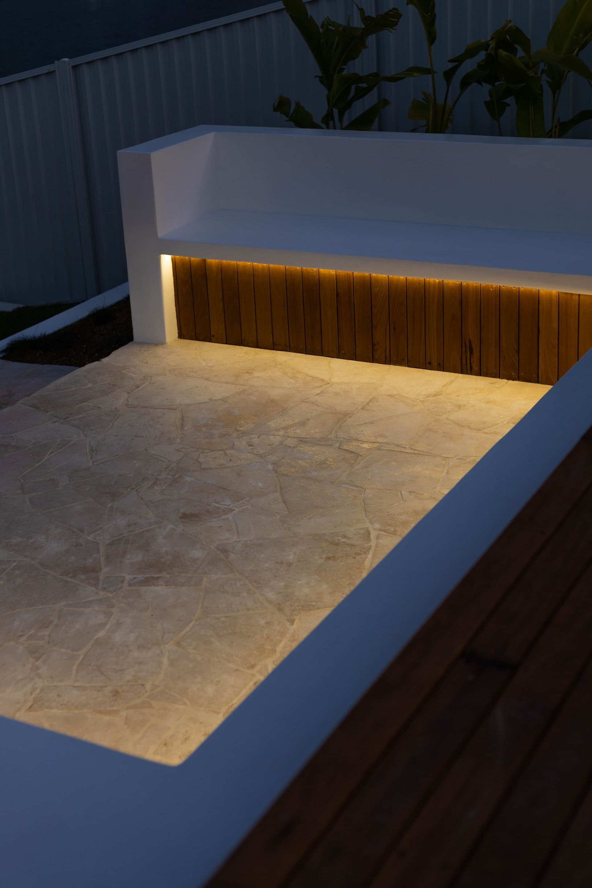 Stone cladding lit up next to timber seating